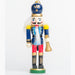 a nutcracker ornament holding a gold bell, wearing a blue and red uniform with a rounded blue and gold hat
