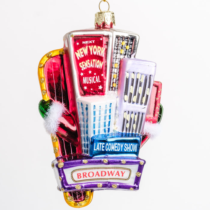 the back of the ornament of Santa waving from in-between Broadway billboard signs displaying skyscrapers