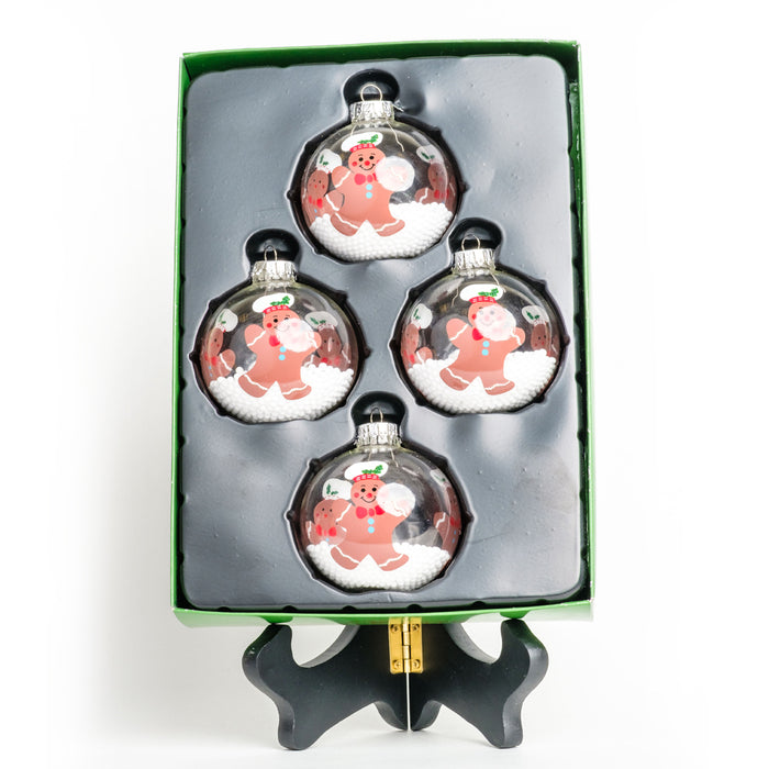a box set of 4 clear ball ornaments of brown gingerbread men in baker's hats & red bow ties with snow pellets on the inside