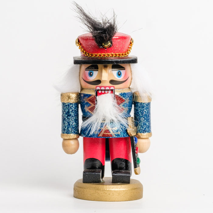 a short soldier nutcracker with a blue, red, and green gemstone sword, wearing a blue and red glitter outfit with a red hat