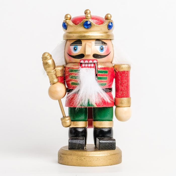 a short king nutcracker holding a gold scepter, wearing a red and green glitter outfit and a red crown with blue gemstones