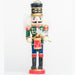 a drummer boy nutcracker ornament playing on a gold and red drum, wearing a green and blue uniform with a black hat