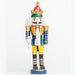a nutcracker ornament holding a silver sword, wearing a yellow and blue uniform with a red, gold, and green crown
