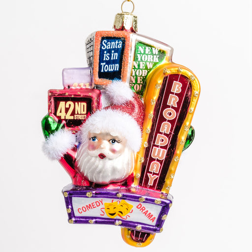 The front view of an ornament with Santa waving from in-between New York’s Times Square billboard signs 