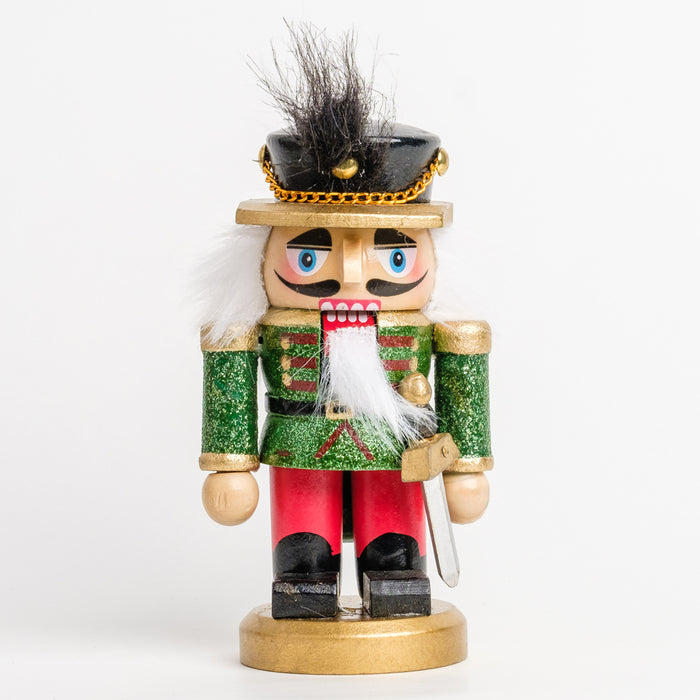 a short soldier nutcracker with a gold and silver sword, wearing a green and red glitter outfit and a black hat